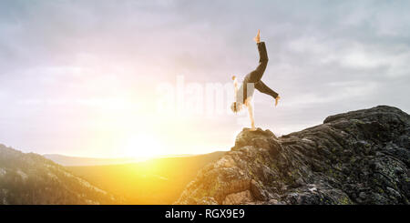 Erstaunlich yoga Mann sie einen Handstand auf Rock. Mixed Media Stockfoto