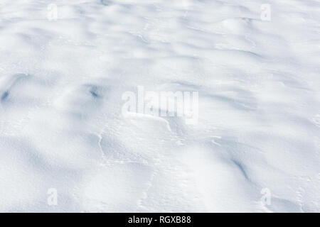 Große Schneeverwehungen auf einem schneebedeckten Feld Stockfoto