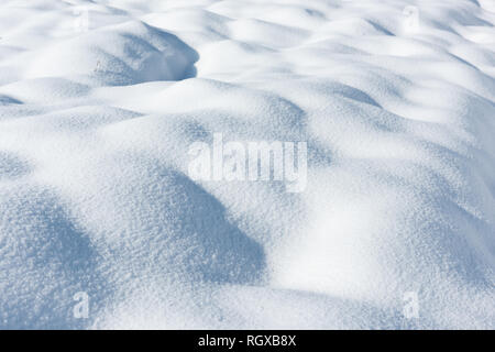 Große Schneeverwehungen auf einem schneebedeckten Feld Stockfoto