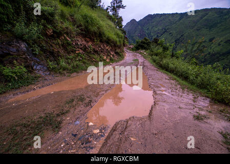 Foto von Schmutz der Straße im Frühjahr in den Bergen mit vielen schlammigen Pfützen nach dem Regen - Sainj Valley, Kullu, Himachal, Indien Stockfoto