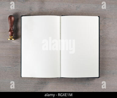 Leeres Buch und Stempel auf Holz- Hintergrund. Flach. Stockfoto