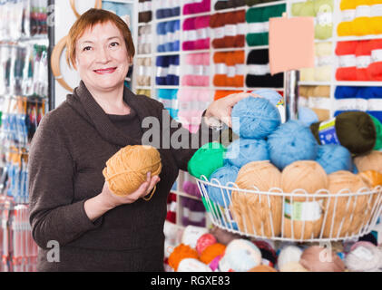 Reife Frau Auswahl Vielzahl Garn für Ihr Hobby in Handarbeit shop Stockfoto