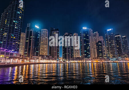 Dubai, Vereinigte Arabische Emirate - Dezember 26, 2017: das Stadtbild von Dubai Marina District in der Nacht. Gebäude mit Licht Reflexion im Wasser. Architektur, Struktur und Design. Reisen und Ferien. Stockfoto