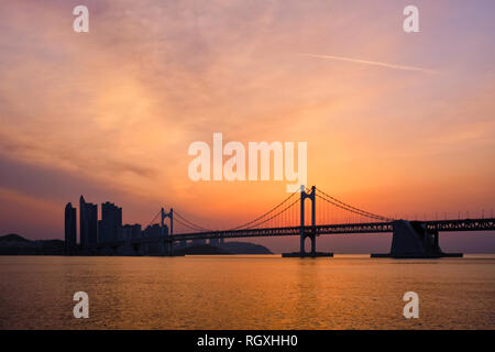 Gwangan Brücke auf sunrise mit Wolkenkratzern und dramatischen Himmel. Busan, Südkorea Stockfoto