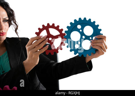 Geschäftsfrau versucht Gänge Stücke zu verbinden. Konzept der Teamarbeit, Partnerschaft und Integration Stockfoto