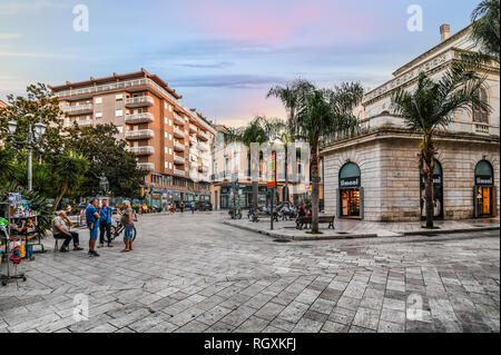 Brindisi, Italien - 13 September 2018: Geschäfte an der Hauptstraße Corso Umberto, als eine Gruppe von älteren italienischen Männern interagieren auf der Straße. Stockfoto