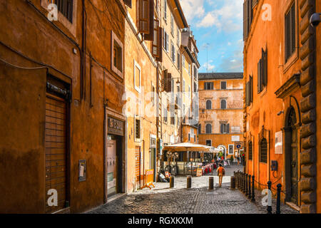 Rom, Italien, 30. September 2018: Eine Frau geht durch eine leere Gasse in Richtung ein Straßencafe und kleinen Piazza im historischen Zentrum von Rom, Italien Stockfoto