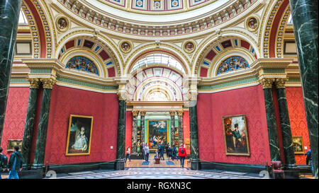 Reich verziertes Kuppelinnere der National Gallery mit roten Wänden und Besuchern, London, England Stockfoto