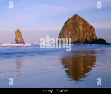 USA, Oregon, Cannon Beach, Sonnenaufgang auf Haystack Rock und eine der Nadeln. Stockfoto