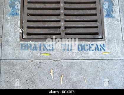 Stenciled 'DRegen zu Ozean' Warnung auf einem Gitter abtropfen lassen und Kanalisation Abdeckung auf eine Straße und Bürgersteig, Pasadena, Kalifornien, USA. Stockfoto