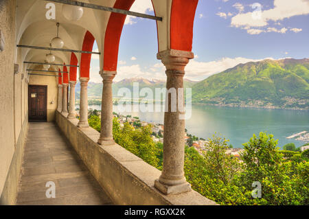 Panoramablick über den Lago Maggiore und die schneebedeckten Berge und Bögen von Kirche Madonna del Sasso in Locarno, Schweiz. Stockfoto