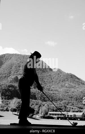 Golfspieler auf der Driving Range mit Blick auf die Berge in der Schweiz. Stockfoto