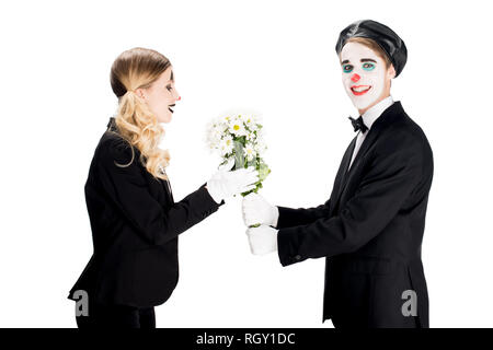 Lächelnde Clown mit Blumenstrauß an Frau isoliert auf weiss Stockfoto