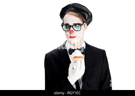 Clown in Anzug und Brille Holding lecker Kuchen isoliert auf weißem Stockfoto