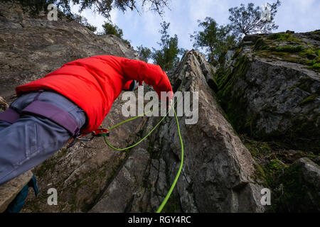 Kletterer sichern, während Ihr Partner Klettern am Rand der Klippe ist. In Area 44 in der Nähe von Squamish und Whistler, nördlich von Vancouver, BC, können Stockfoto