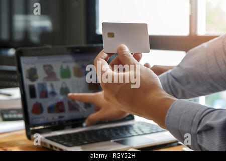 Unternehmer, die Kreditkarte und mit Laptop. Die Zahlung beim Online shopping. E-Commerce und moderne Technik Konzept Stockfoto