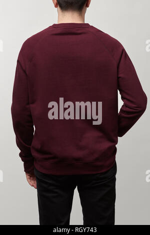 Rückansicht des Menschen in Burgund sweatshirt mit Kopie Raum isoliert auf Grau Stockfoto