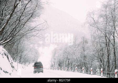 SUV-Auto auf verschneiter Straße im Winter Hügel Berge Landschaft, Georgia. Antriebs- und Reise, Travel Concept. Snowy Land Straße im Winter. Stockfoto