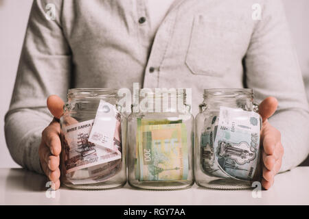 7/8 Schuß von Mann mit Gläsern mit russischer Rubel Banknoten Stockfoto