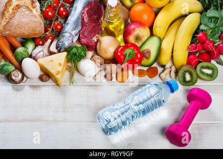 Gesunder Lebensstil und Gesundheit Konzept. Gesundes Essen, eine Flasche Wasser und Hantel auf Tisch Stockfoto