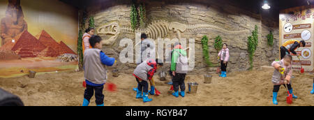 QingYuan China Dezember 31,2018: kid Aushub Dinosaurier fossil auf Sand. Stockfoto