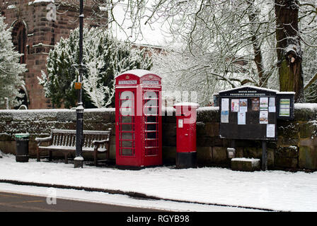 Old Phone Box und Schnee im Prestbury Village Stockfoto