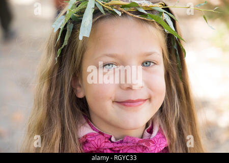 Lächelnde Mädchen tragen handgemachte Kranz aus Weide Zweigen Stockfoto