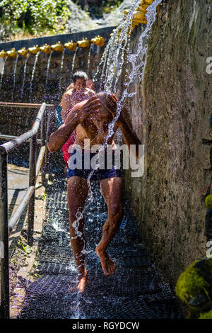 Pilger, die Dusche an der 108 Brunnen Ausgaben eiskalten heiligen Wasser in Muktinath Bügel Stockfoto