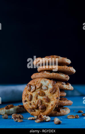 Runde orange Biscuits mit bunten kandierte Früchte und ein Stück saftige Orange liegen auf einem Holztisch. Nahaufnahme Stockfoto