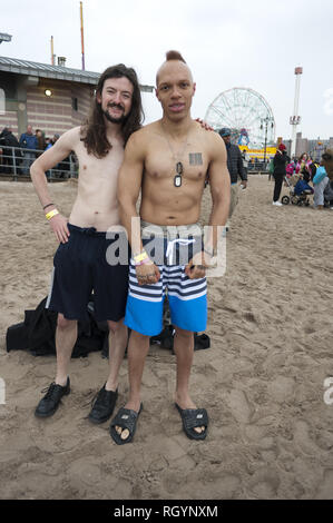 Junge Männer bei Polar Bear Club schwimmen am Neujahrstag auf Coney Island in Brooklyn, NY, 2011. Die Worte "hattered Träume" sind tätowiert auf einer der Männer Stockfoto