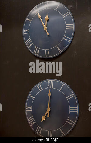 Viele verschiedene Wanduhr auf der Wand. Satz von clockfaces isoliert. Konzept der zeit management. Mehrere Uhren mit verschiedenen Zeit. Schwarz Wanduhren Stockfoto