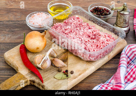 Rohes Hackfleisch mit Gewürzen zum Kochen auf Holzbrett. Studio Foto Stockfoto