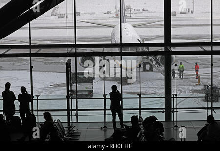 31. Januar 2019, Nordrhein-Westfalen, Köln: Reisende warten vor schneebedeckten Flugzeuge am Flughafen Köln/Bonn in der Klemme. Der Flughafen wurde nach Schneefällen geschlossen. Foto: Oliver Berg/dpa Stockfoto