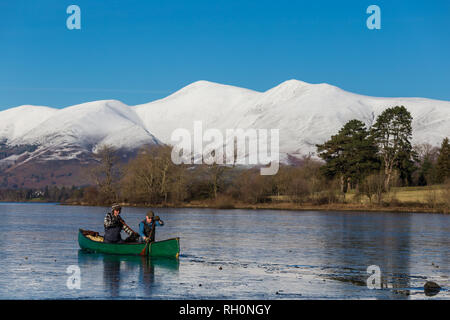 Lake District, England. 31. Januar 2019. Zwei Männer, ein Hund und ein Kanu versuchen, gefroren Teile von Derwent Water, einem der wichtigsten Gewässer im Lake District National Park zu überqueren. Quelle: Thomas Holmes/Alamy leben Nachrichten Stockfoto