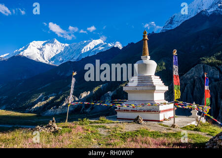 Eine weiße Chorten, Stupa, über der Stadt gelegen, bunte buddhistische Gebetsfahnen flattern in der Luft, der Schnee Gipfel der Annapurna 2 Im distan abgedeckt Stockfoto