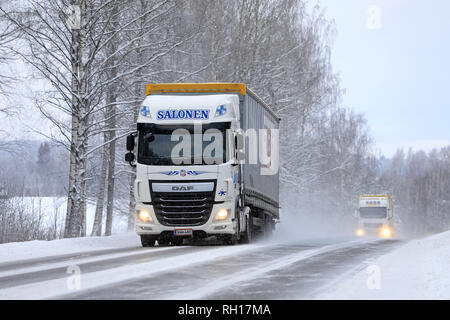 Salo, Finnland - Januar 27, 2019: Zwei weiße Auflieger Lkw, DAF XF Salonen im vorderen, schleppen waren auf Landstraße in Schneefall. Stockfoto