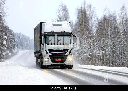 Salo, Finnland - Januar 27, 2019: Weiß Iveco Stralis truck zieht Trailer entlang der schneebedeckten Straße im Winter Schneefall im Süden Finnlands. Stockfoto