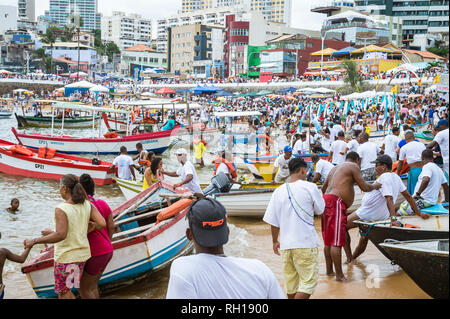 SALVADOR, Brasilien - Februar 02, 2016: Fischer im Dorf Rio Vermelho ihren Fischerbooten bieten zu Feiernden auf dem Festival von yemanja. Stockfoto