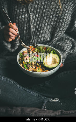 Frau das Essen von frischem Salat, Avocado, Bohnen und Gemüse aus der Schüssel Stockfoto