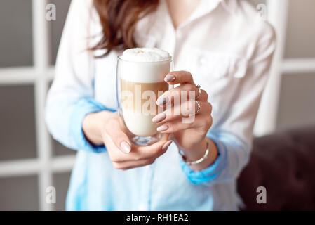 In der Nähe der weiblichen Händen im Büro Kleidung hält ein Glas Tasse Kaffee mit Sojamilch während einer Pause bei der Arbeit, Lifestyle Konzept Stockfoto