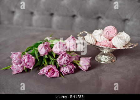 Lavendel Lila Tulpen neben einem vintage Metall Vase mit hausgemachten Marshmallow in einem eleganten Interieur, congratulatory Konzept Stockfoto