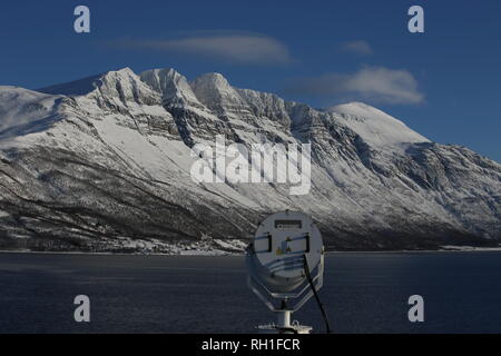 Felsformation im Tromsö-Fjord, Im Vordergrund ein Suchscheinwerfer Stockfoto