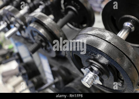 Kurzhanteln auf Rack in der Turnhalle. Konzept der Fitnesscenter, Sportgeräte, Bodybuilding, Gewichtheben Stockfoto