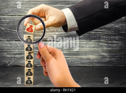 Geschäftsmann entfernt einen Cube mit einem Bild von Dollar. Die Finanz- und Wirtschaftskrise. kapitalabfluss. Sabotage der Wirtschaft. Konkurs. Druck auf Stockfoto