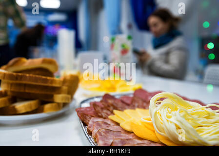 Scheiben Käse und Fleisch auf dem Teller am Tisch Stockfoto