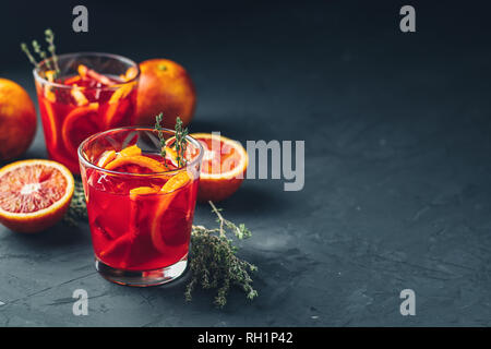 Rot Orange Saft in ein großes Glas oder Blut orange Sparkling vodka Cocktail oder Aperitif mit Campari auf dunklen konkreten Hintergrund, kopieren Spice, flachen d Stockfoto
