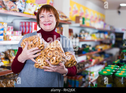 Freundliche ältere Frau Verbraucher mit Backwaren in der Lebensmittel Shop Stockfoto