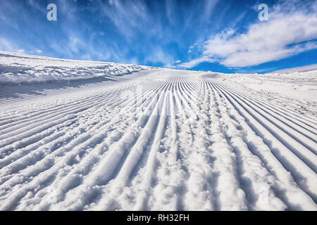 Leere Spur im Skigebiet nach dem Lastwagen. Sonnigen Tag. Ski Trail in Karakol, Kirgisien. Schöne Aussicht in die Schlucht. Wunderschöner Ort. Stockfoto