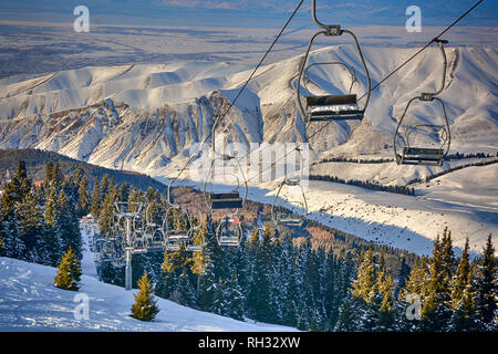 Schöne Aussicht von der Spitze des Berges mit modernen Stühlen und Wald in Karakol, Kirgisien. Stockfoto