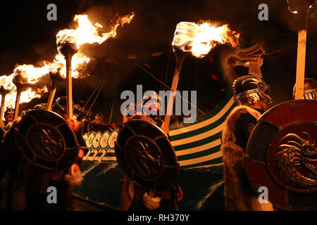 Mitglieder der Jarl Squad März neben der Küche, wie sie durch die lerwick vor der Kombüse auf Feuer auf den Shetland Inseln während der Up Helly Aa Wikinger Fest gesetzt wird. Mit Ursprung in den 1880er Jahren, das Festival feiert den Shetland nordischen Erbe. PRESS ASSOCIATION Foto. Bild Datum: Dienstag, Januar 29, 2019. Stockfoto